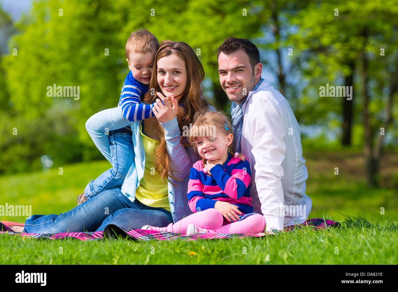 Happy family with daughter and son walking on a meadow in summer Stock Photo
