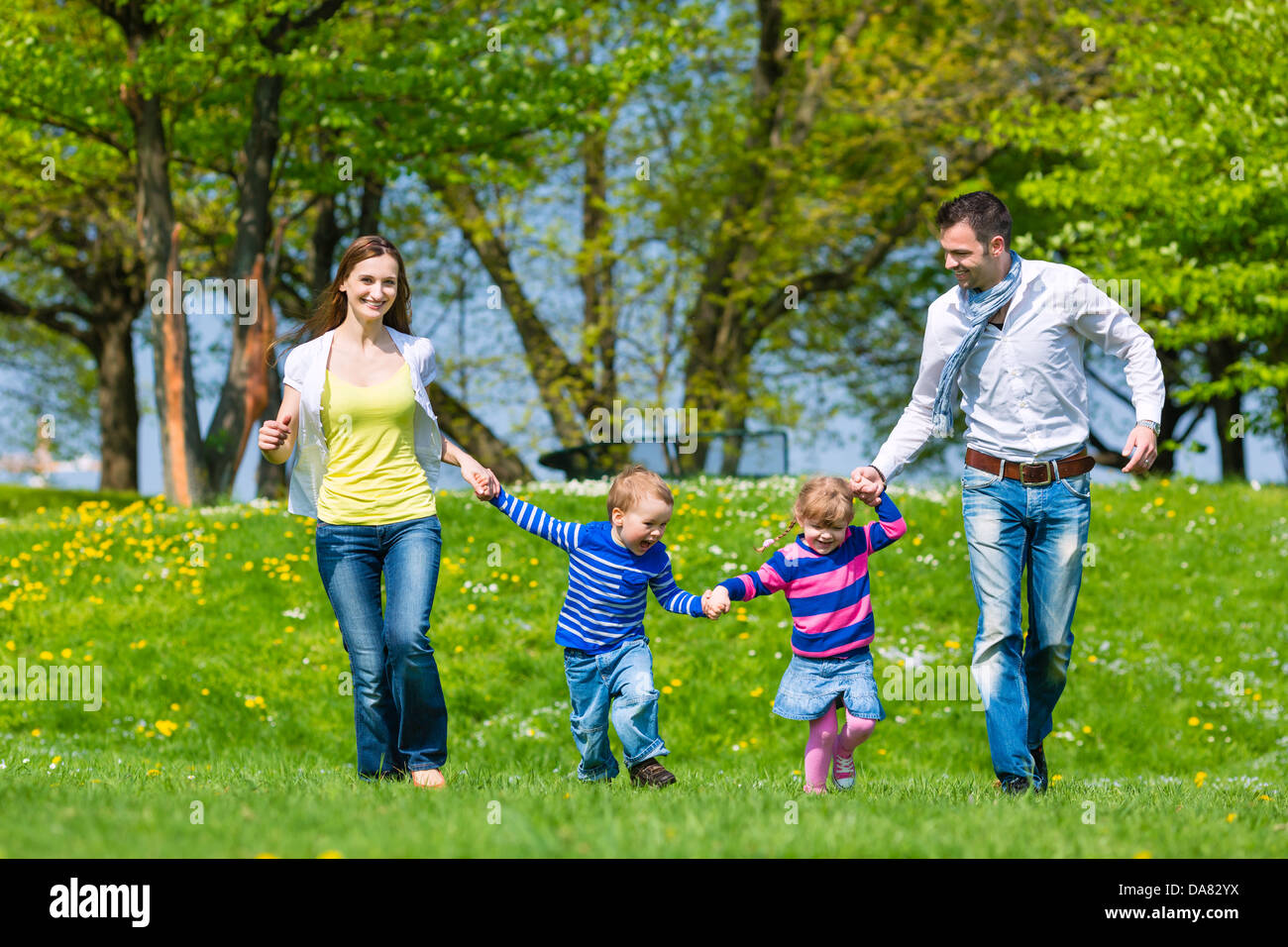 Happy family with daughter and son walking on a meadow in summer Stock Photo