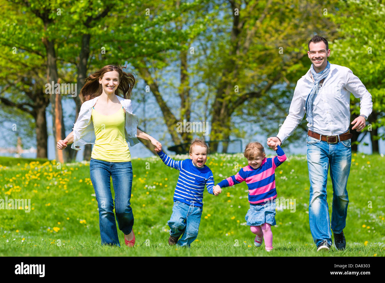 Happy family with daughter and son walking on a meadow in summer Stock Photo