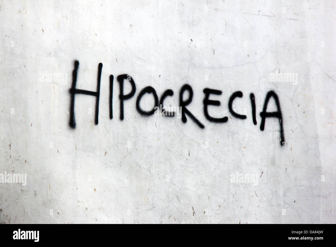 The word 'hypocrisy' in Spanish written on a wall. Stock Photo