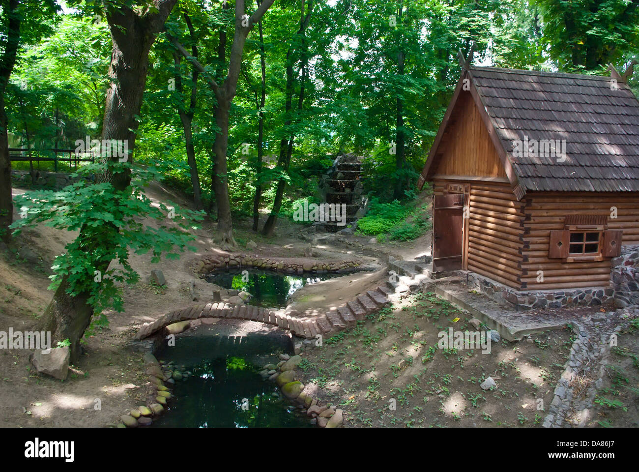 Green park with small pond and wood house in Kiev, Ukraine Stock Photo