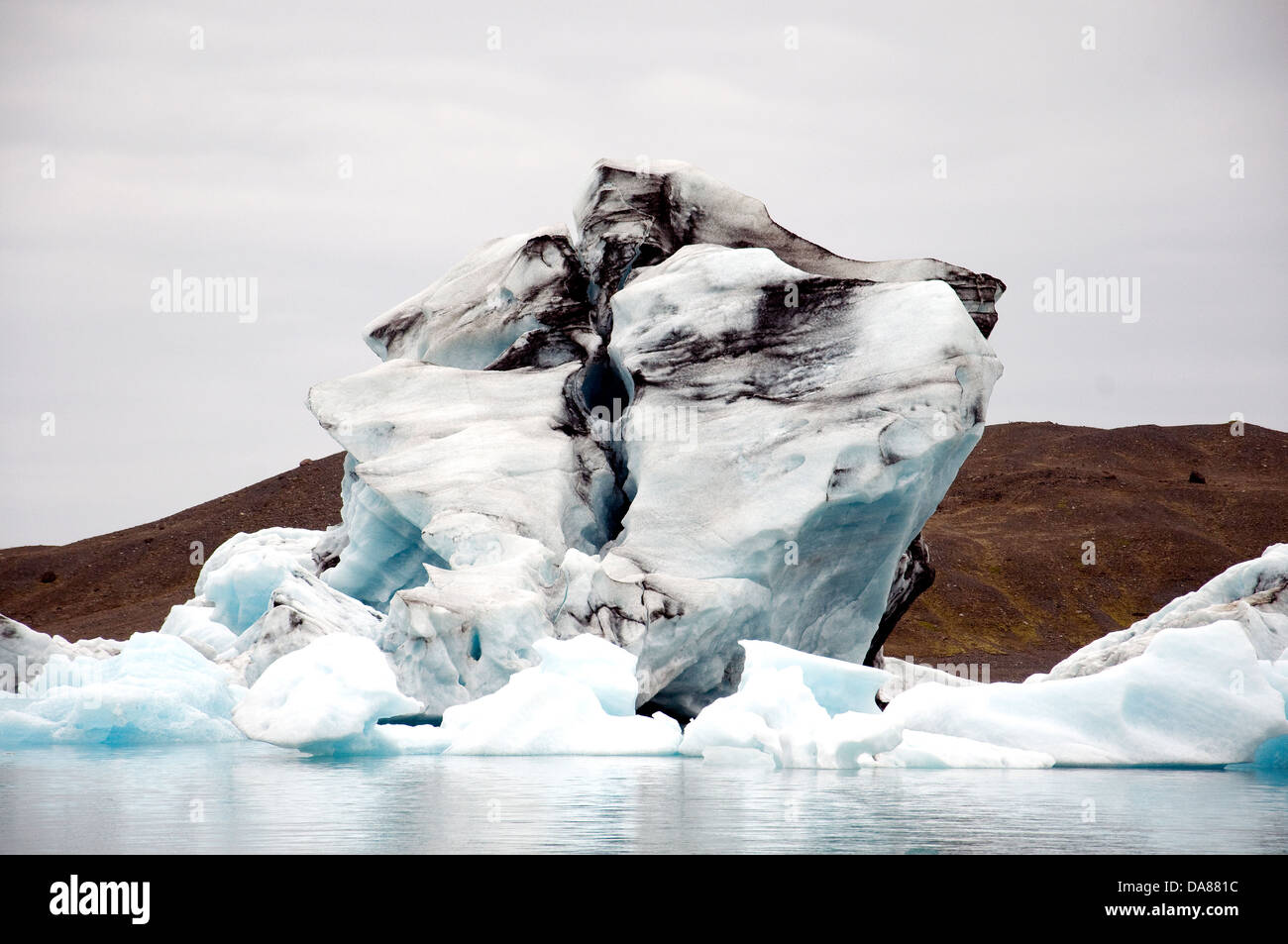 A quirk of nature places a black-topped iceberg among other bergs in Iceland's Jokulsarlon glacier lagoon Stock Photo