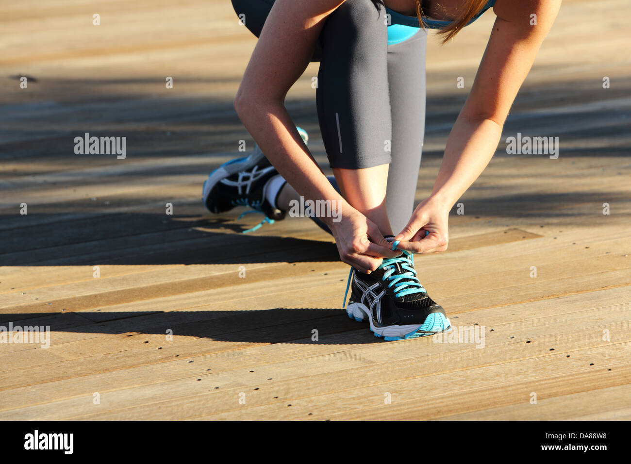 Female runner tying her shoe Stock Photo Alamy