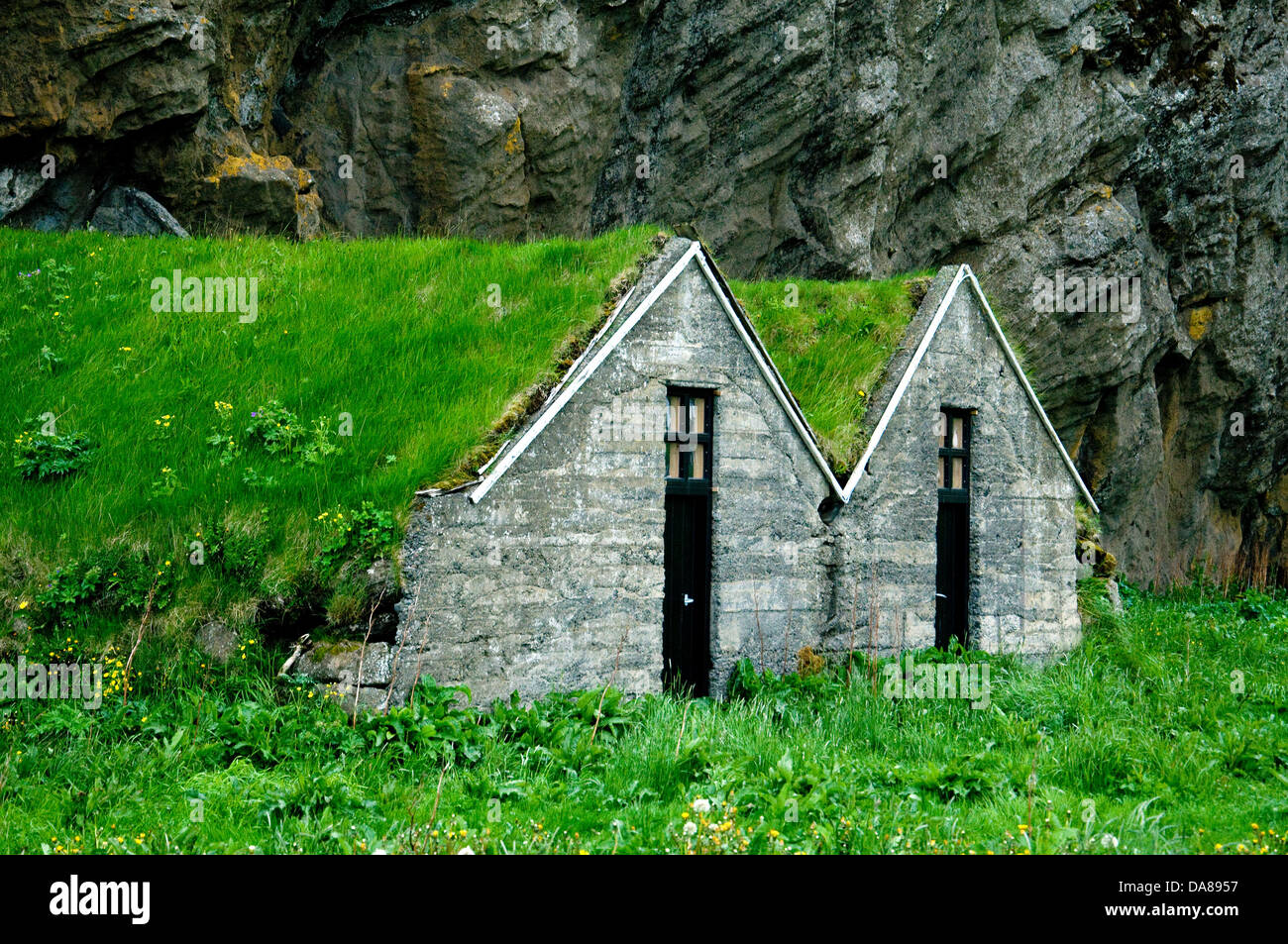 Modern farm storage in Iceland still uses an old trick for insulation--turf-covered roofing Stock Photo