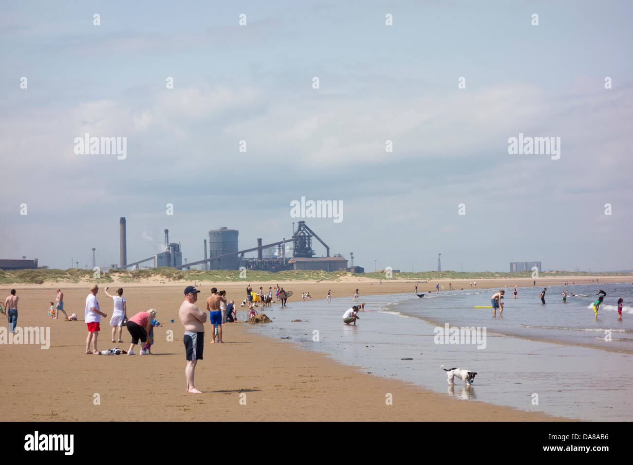 Redcar, UK. 7th July, 2013. People bathing in the North Sea on a calm and hot Sunday on Redcar beach. Teesside Offshore Winfarm in distance Credit:  ALANDAWSONPHOTOGRAPHY/Alamy Live News Stock Photo