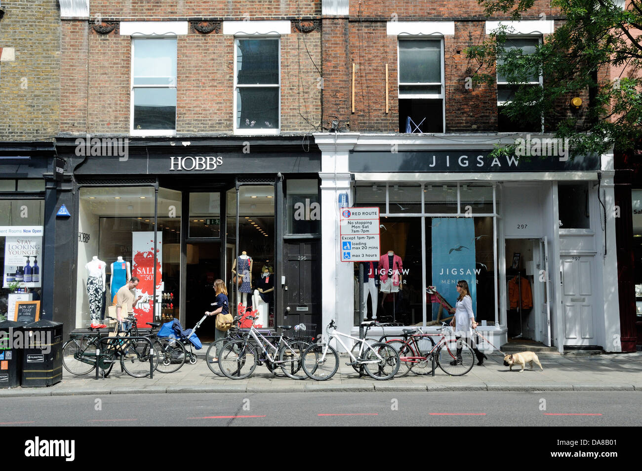 Hobbs and Jigsaw shops with people passing and bikes attached to racks in front, Upper Street