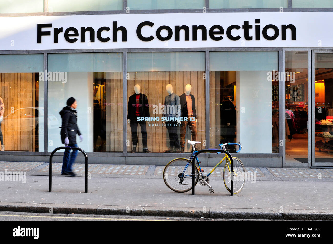 A woman walks past French Connection shop in central London, UK. Stock Photo