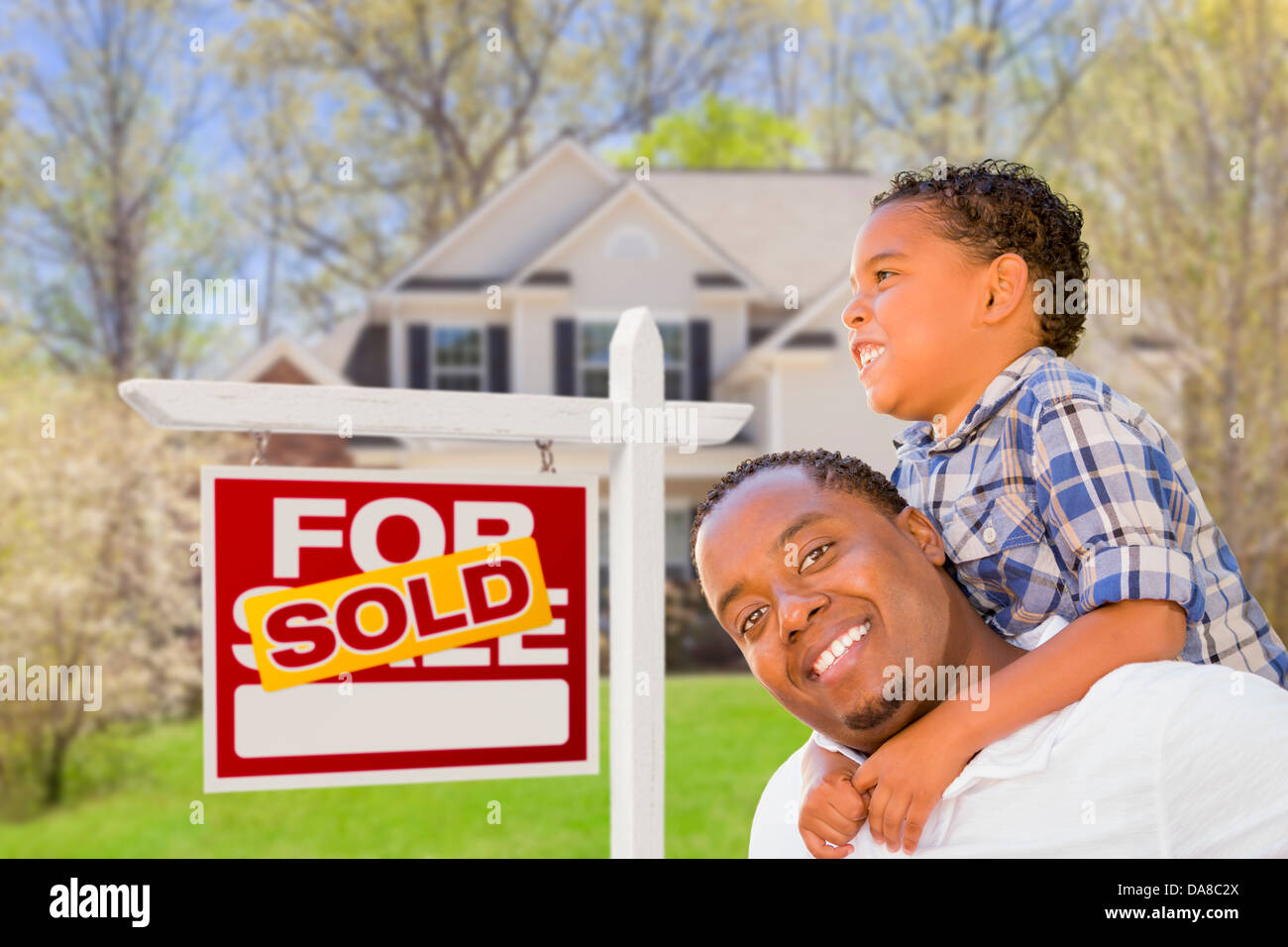 Happy Mixed Race Father and Son In Front of Sold Real Estate Sign and ...