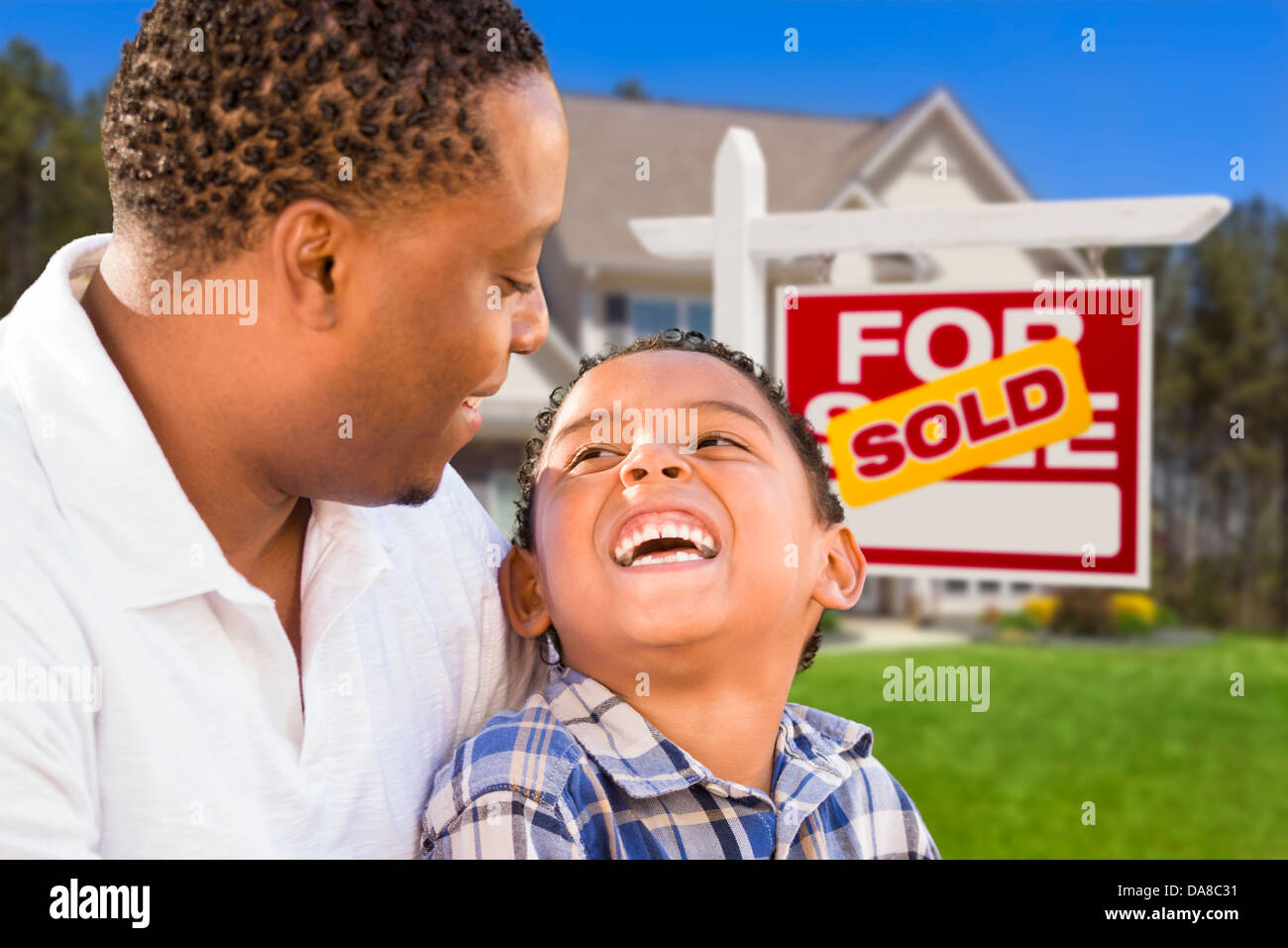 Happy Mixed Race Father and Son In Front of Sold Real Estate Sign and ...