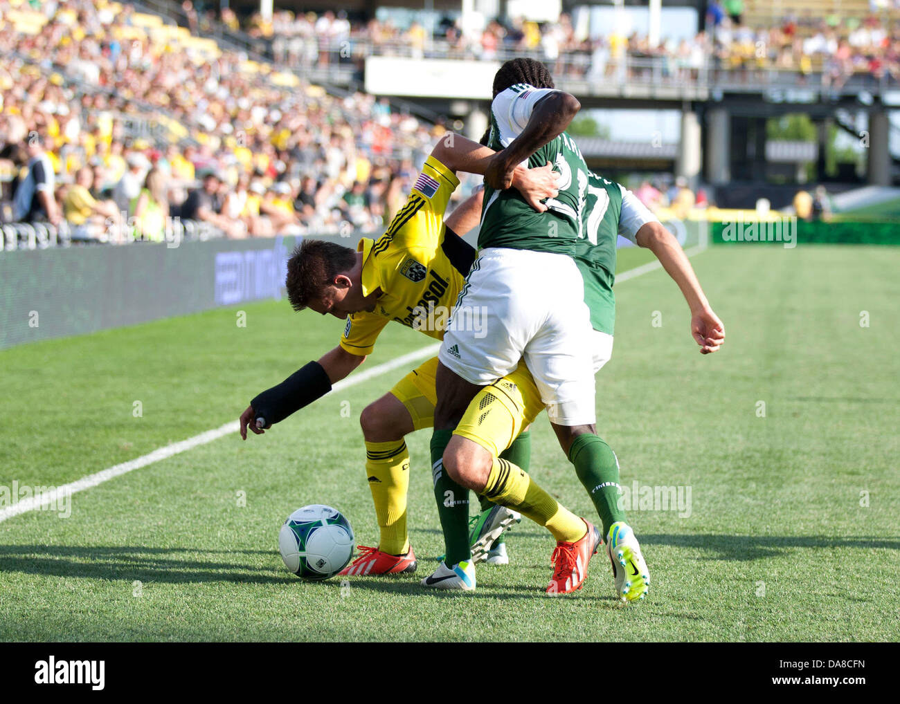Columbus, OH, USA. 7th July, 2013. July 07, 2013: Columbus Crew Ethan Finlay (13) is tangled up with Portland Timbers Diego Chara (21) and Michael Nanchoff (17) as he battles for the ball during the Major League Soccer match between the Portland Timbers and the Columbus Crew at Columbus Crew Stadium in Columbus, OH. The Columbus Crew defeated the Portland Timbers 1-0. Credit:  csm/Alamy Live News Stock Photo