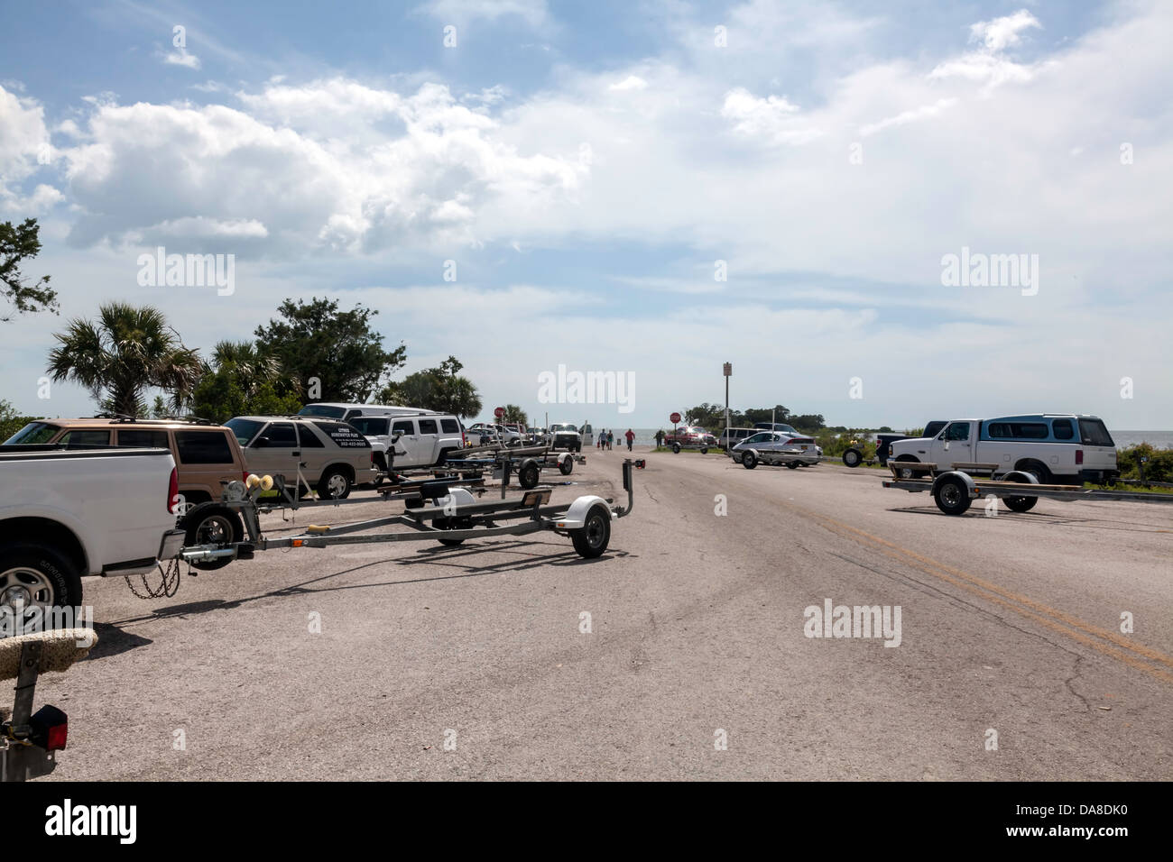 Vehicles and boat trailers parked along the road leading to the public