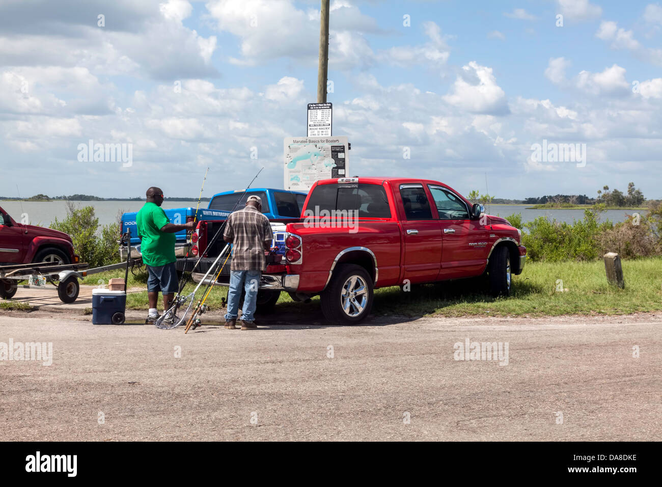 Two men unloading fishing poles and equipment from bed of a red pickup truck  parked at the boat ramp and dock near Yankeetown Stock Photo - Alamy