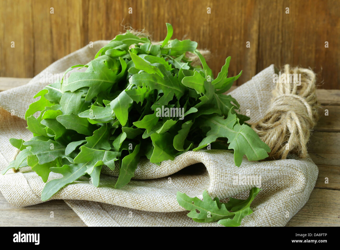 bunch of fresh green arugula on the wooden table Stock Photo