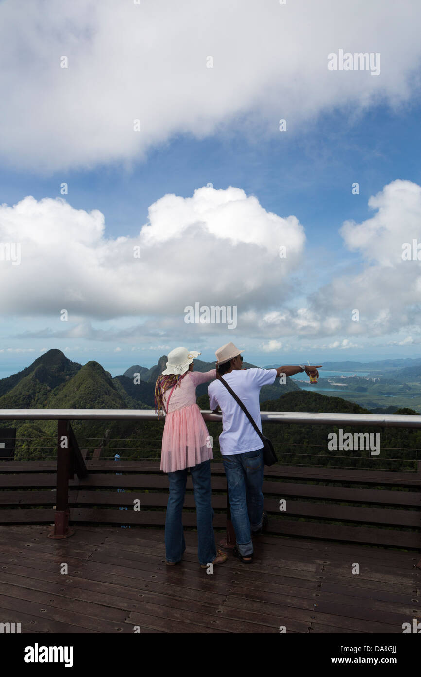 Two Caucasian tourists pointing at the landscape from the Langkawi viewing platform, Malaysia Stock Photo