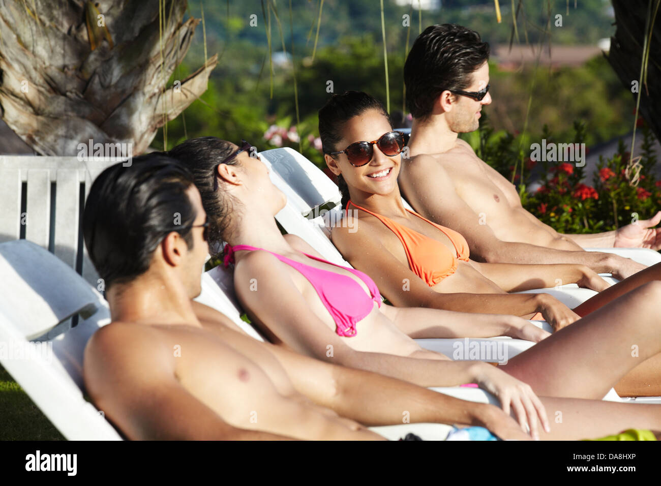Friends relaxing poolside. Stock Photo