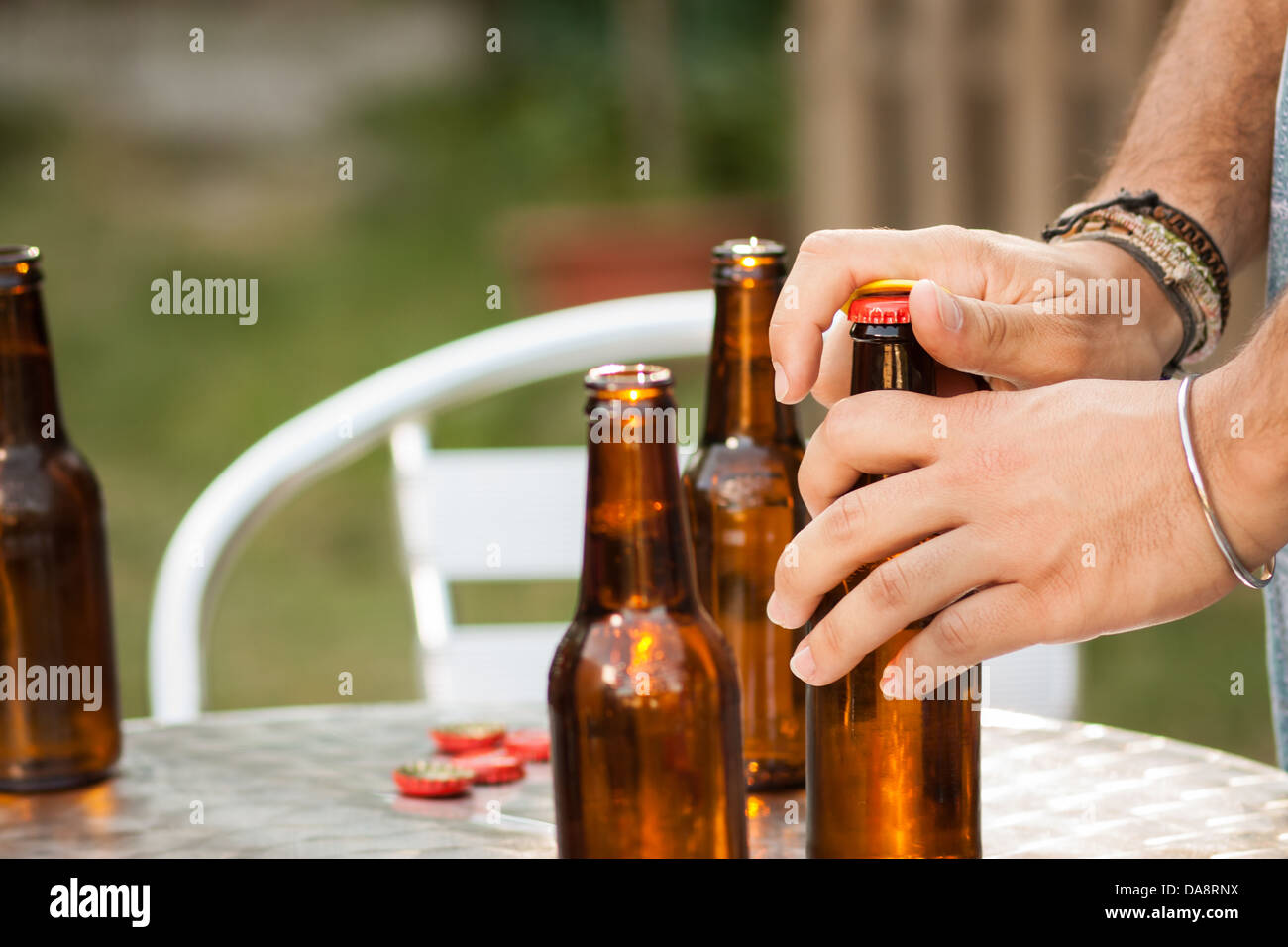 Hand opening a beer bottle in a terrace outdoors Stock Photo