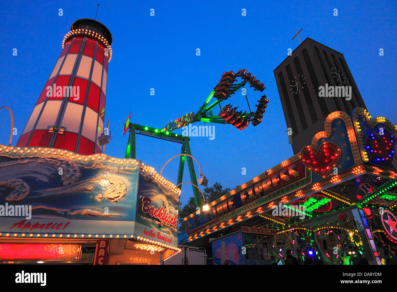 D-Oberhausen, D-Oberhausen-Sterkrade, Lower Rhine, Ruhr area, Rhineland, North Rhine-Westphalia, NRW, traditions, Corpus Christi kermess in Sterkrade, street festival, funfair, evening, thrill ride, church tower of the priory church Saint Clemens Stock Photo