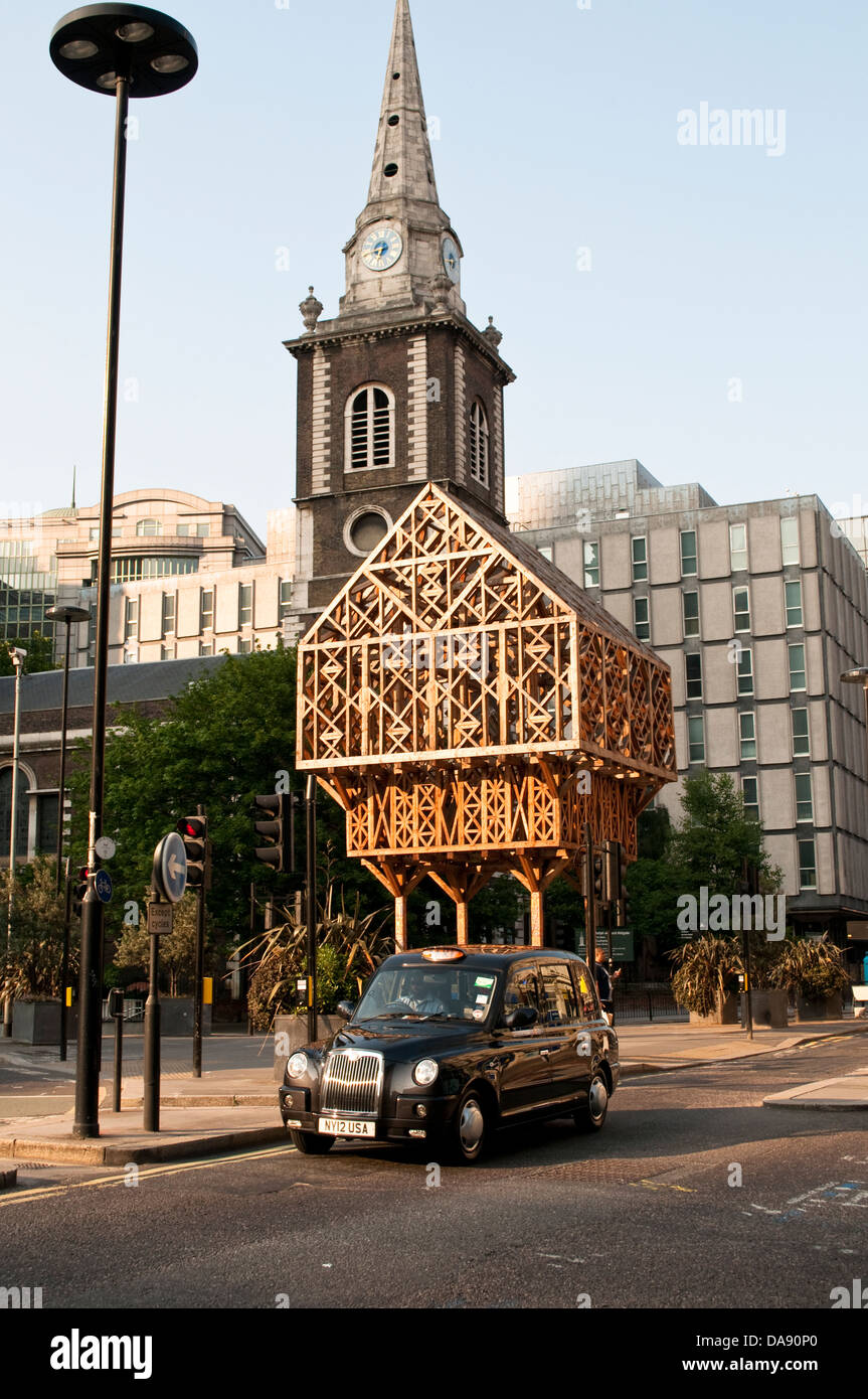 Paleys upon Pilers by Studio Weave, a latticed timber hut on stilts at Aldgate, and St Botolph Church, City of London, Uk Stock Photo