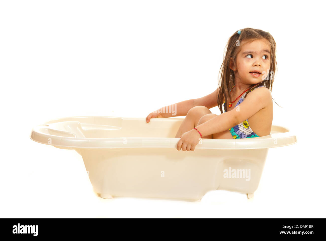 Cute preschool girl in washtub looking away to copy space isolated on white background Stock Photo