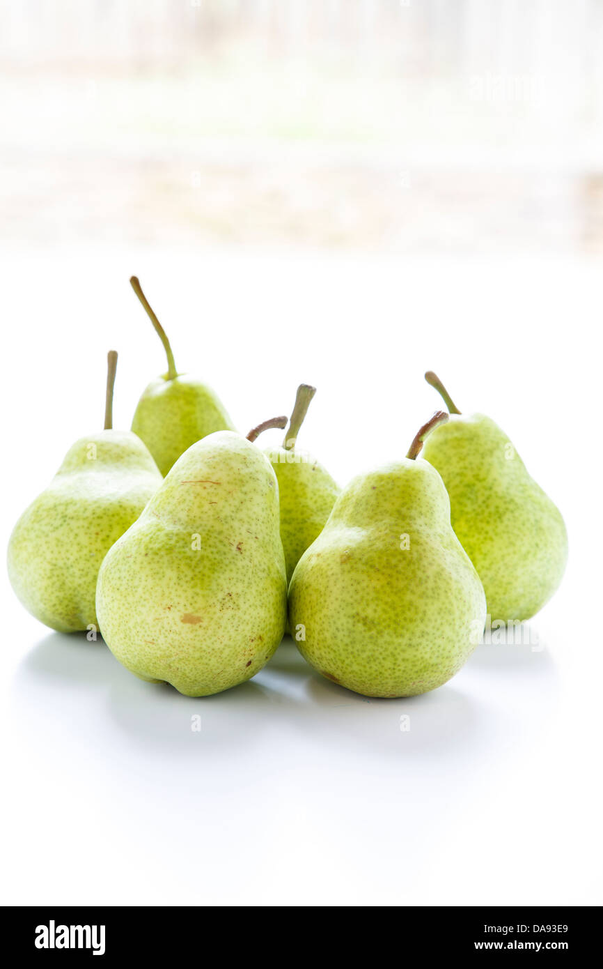 Green Bartlett pears on a white counter in window light Stock Photo