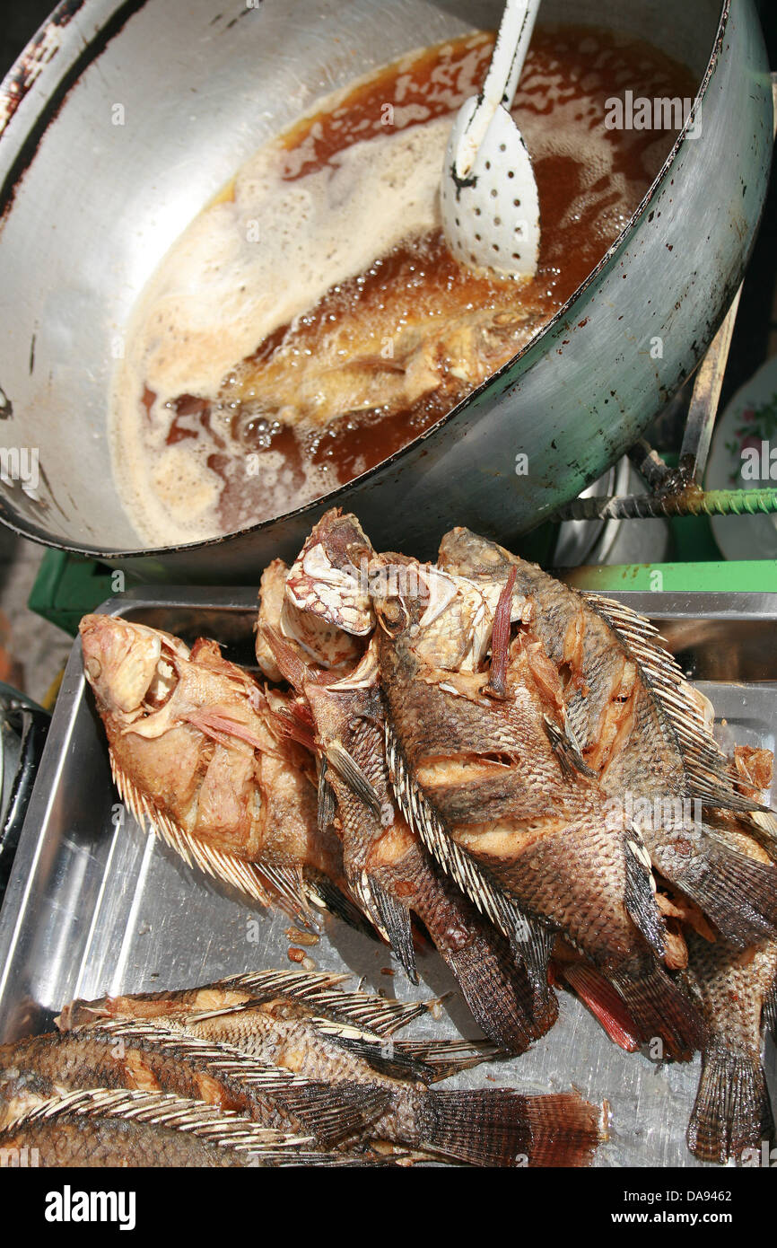 Fried Tilapia fish are deep fried and sold at an outdoor food market in