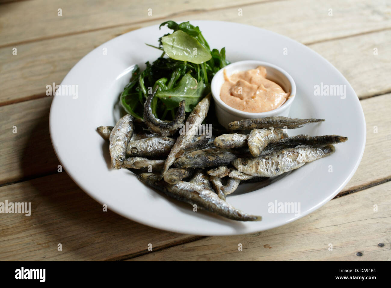 Whitebait deep fried with cayenne mayonnaise dip and a green side salad of Rocket Stock Photo