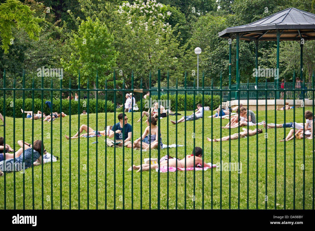 People resting in a public park during summer - Jardin Villemin, Paris Stock Photo