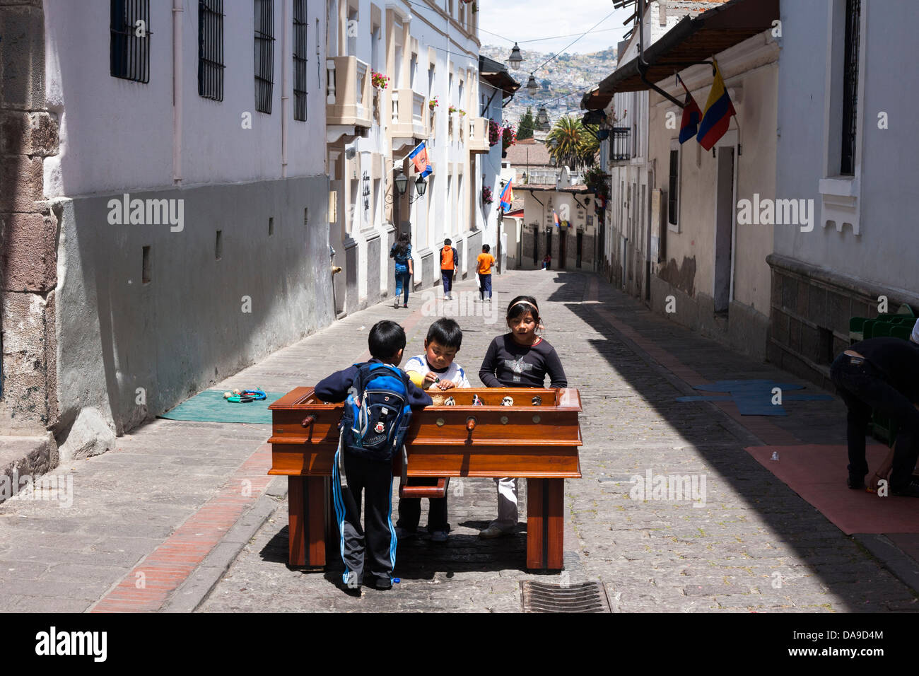 School children play table futbol on a table in the historic district of Quito in a program set up by a charity. Stock Photo