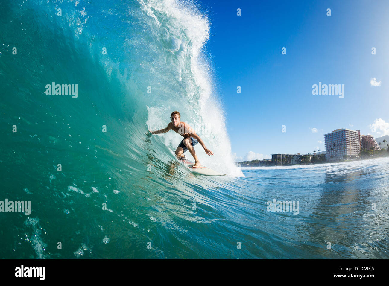 Surfer on Blue Ocean Wave Getting Barreled Stock Photo