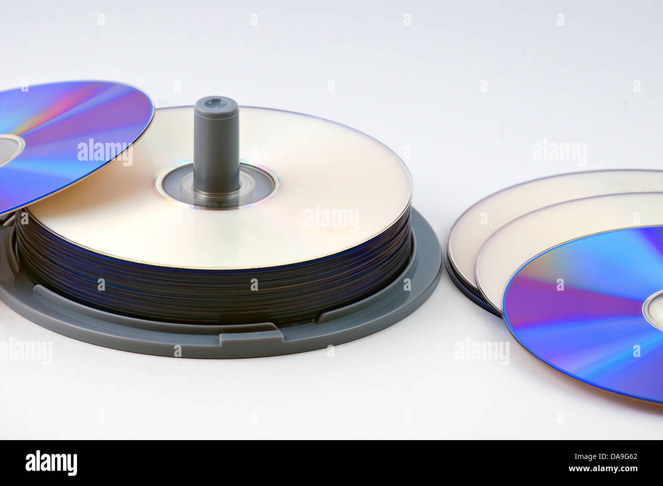 CD-R data discs in a stack with several laid out on the desk Stock Photo