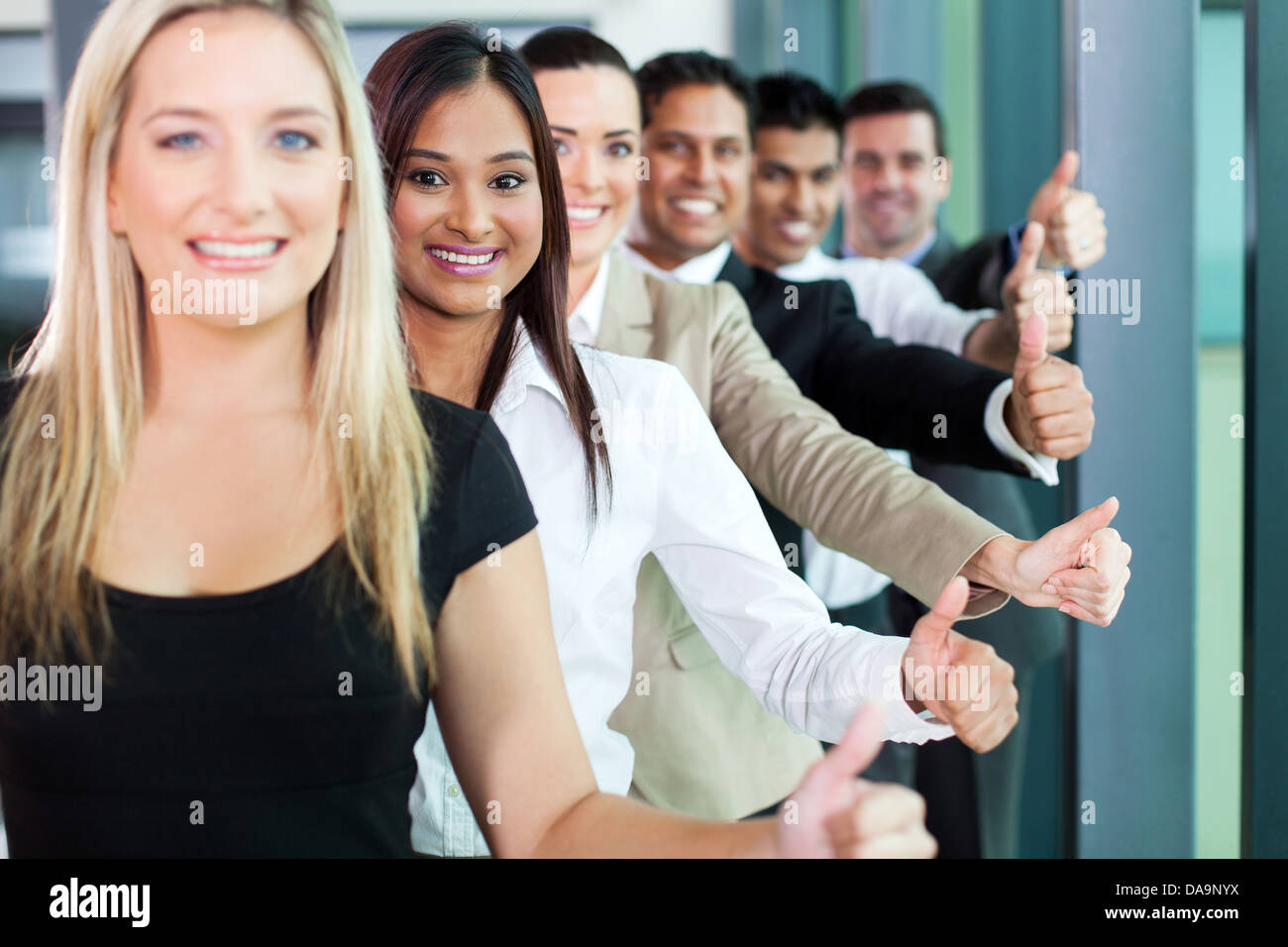 row of smiling business team giving thumbs up Stock Photo - Alamy