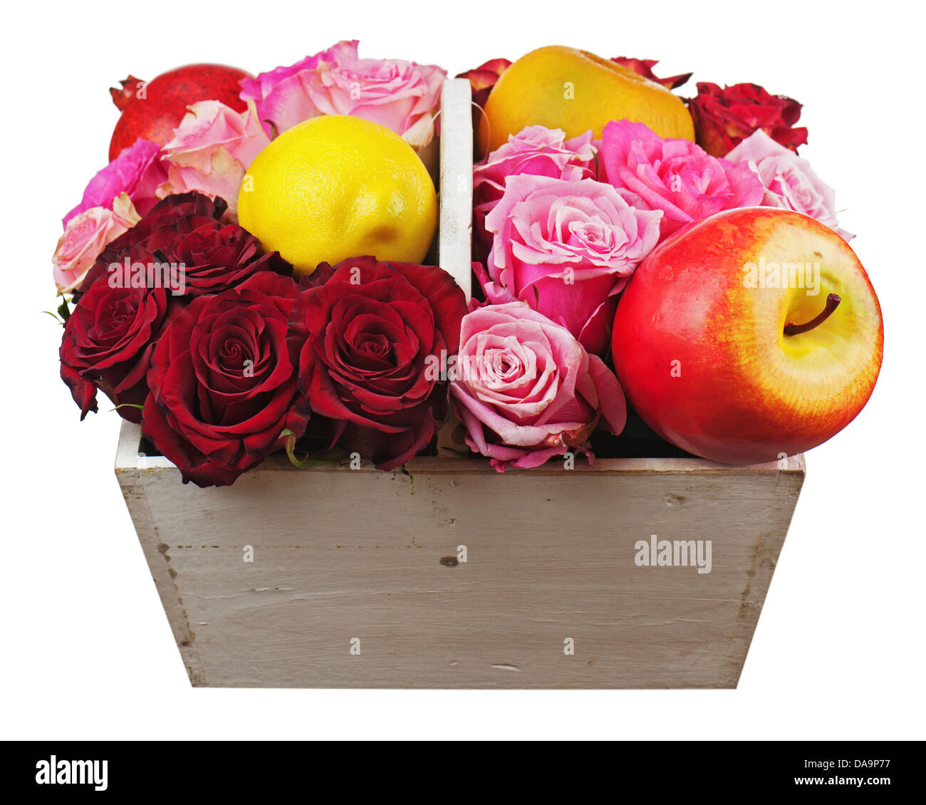Flower arrangement of red roses and fruits in wooden basket isolated on