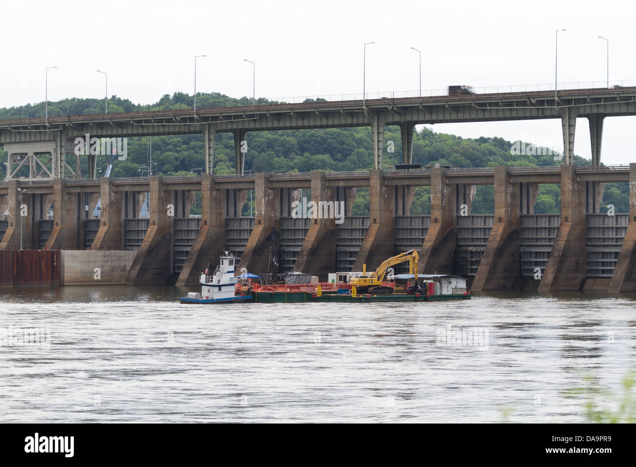 A barge operates below the Chickamauga Dam on the Tennessee River under cloudy skies Stock Photo