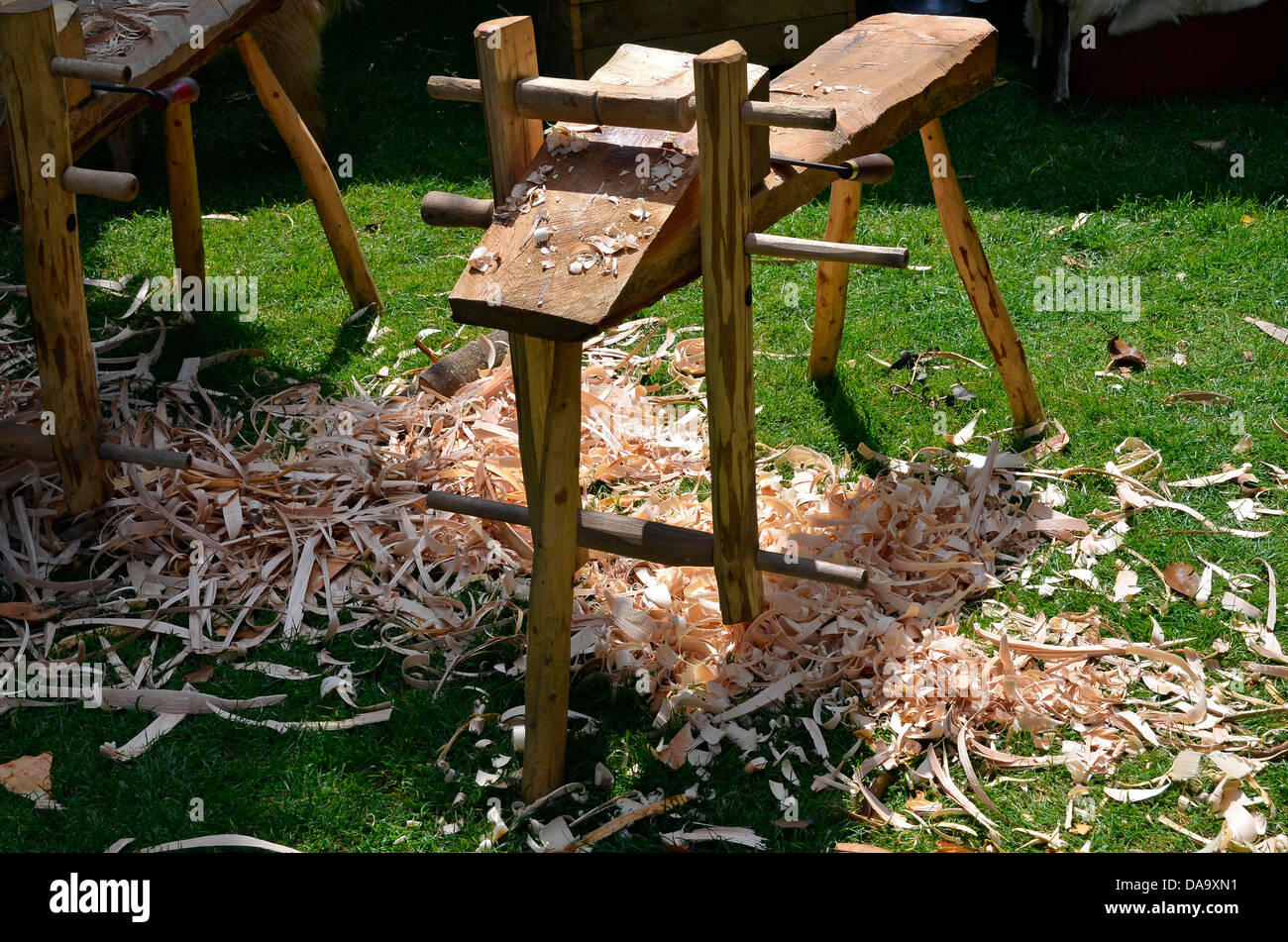 Woodsman or bodgers shave horse with shavings scattered on the ground - part of a demonstration at a country fair. Stock Photo
