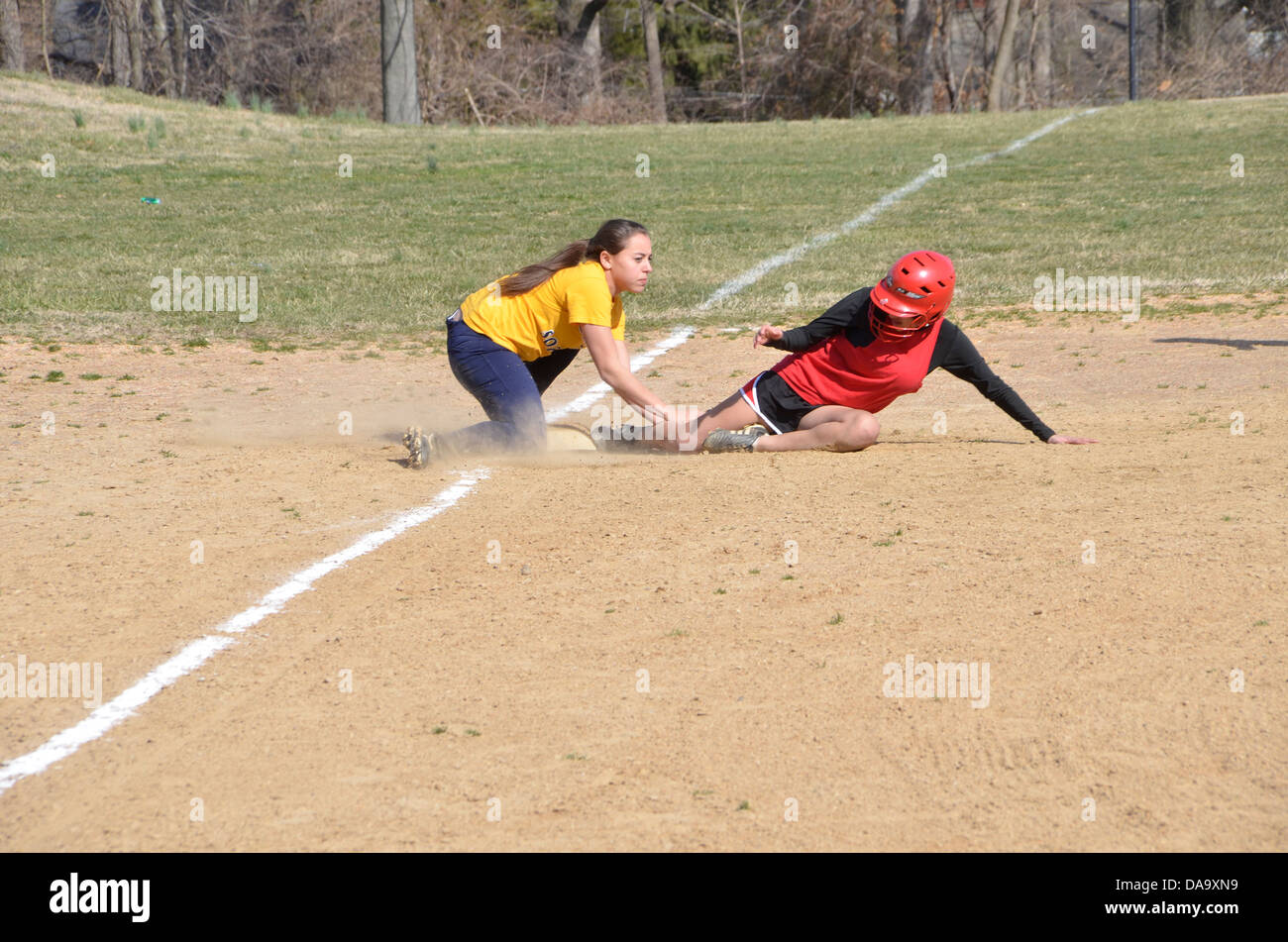 high school softball runner sliding into 3rd base Stock Photo Alamy