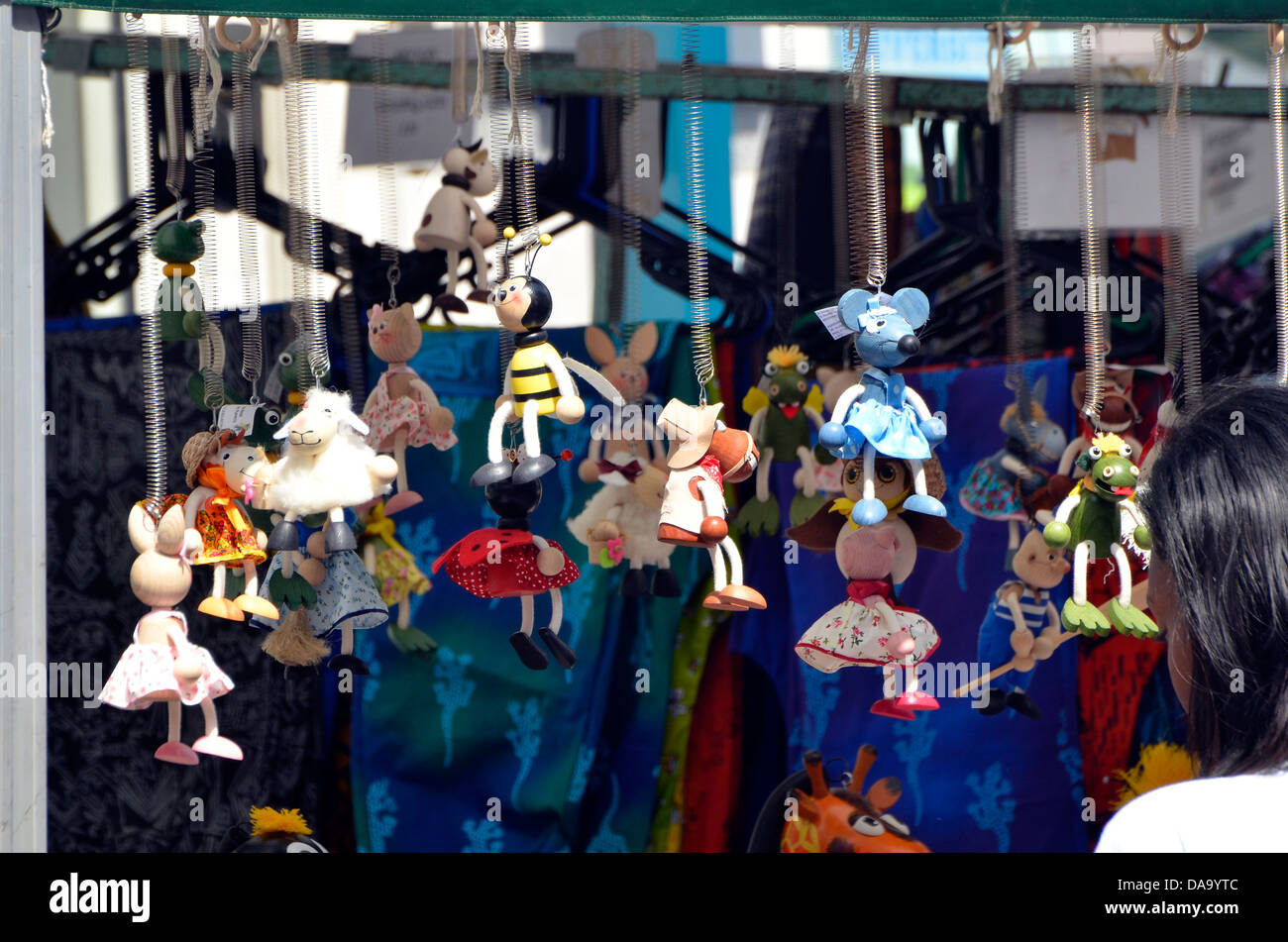 Woman looking at character toy mobiles on a market stall during Winchester Hat Fair 2013. Stock Photo