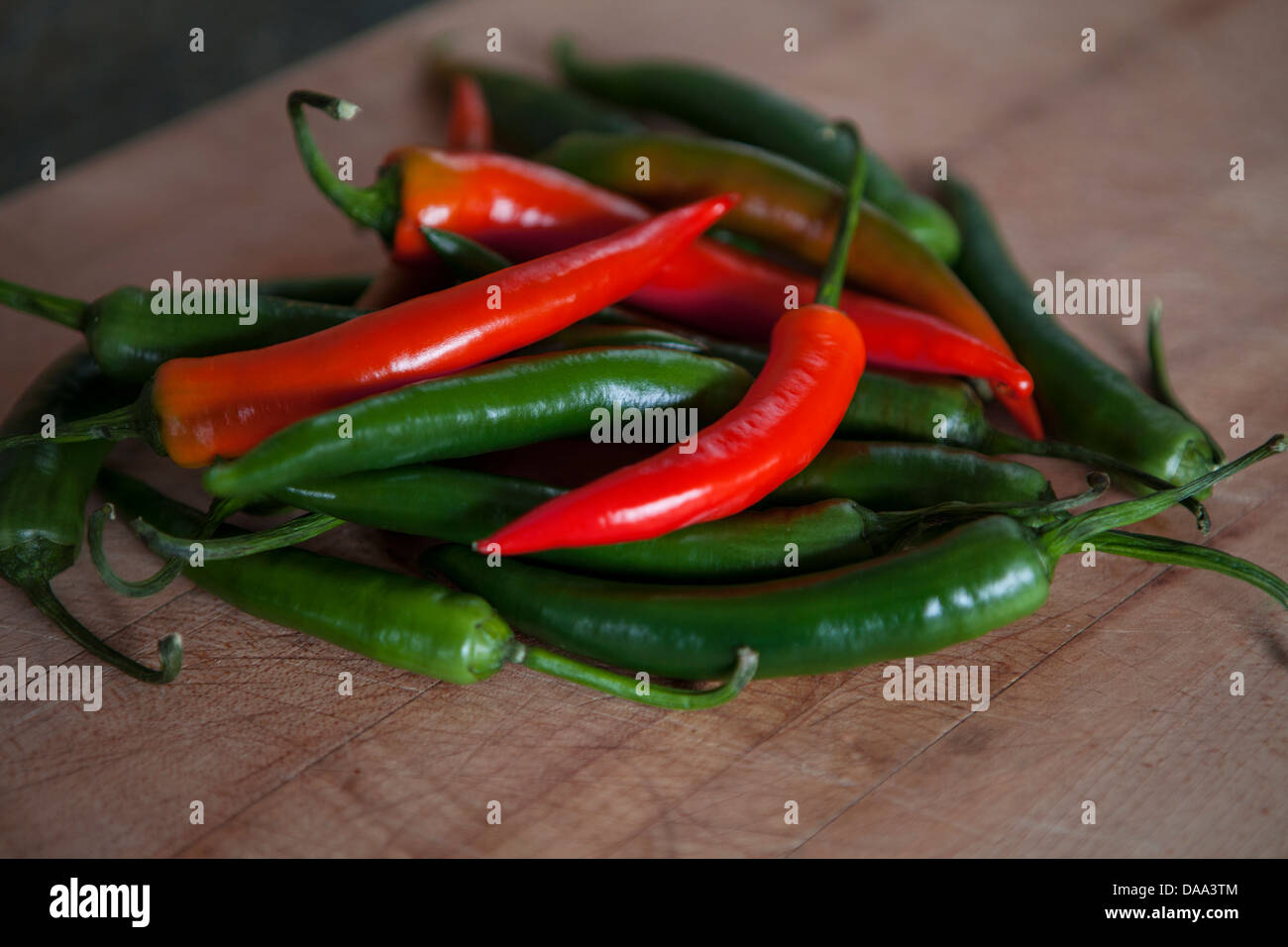 Red hot chillies peppers on a chopping board Stock Photo - Alamy