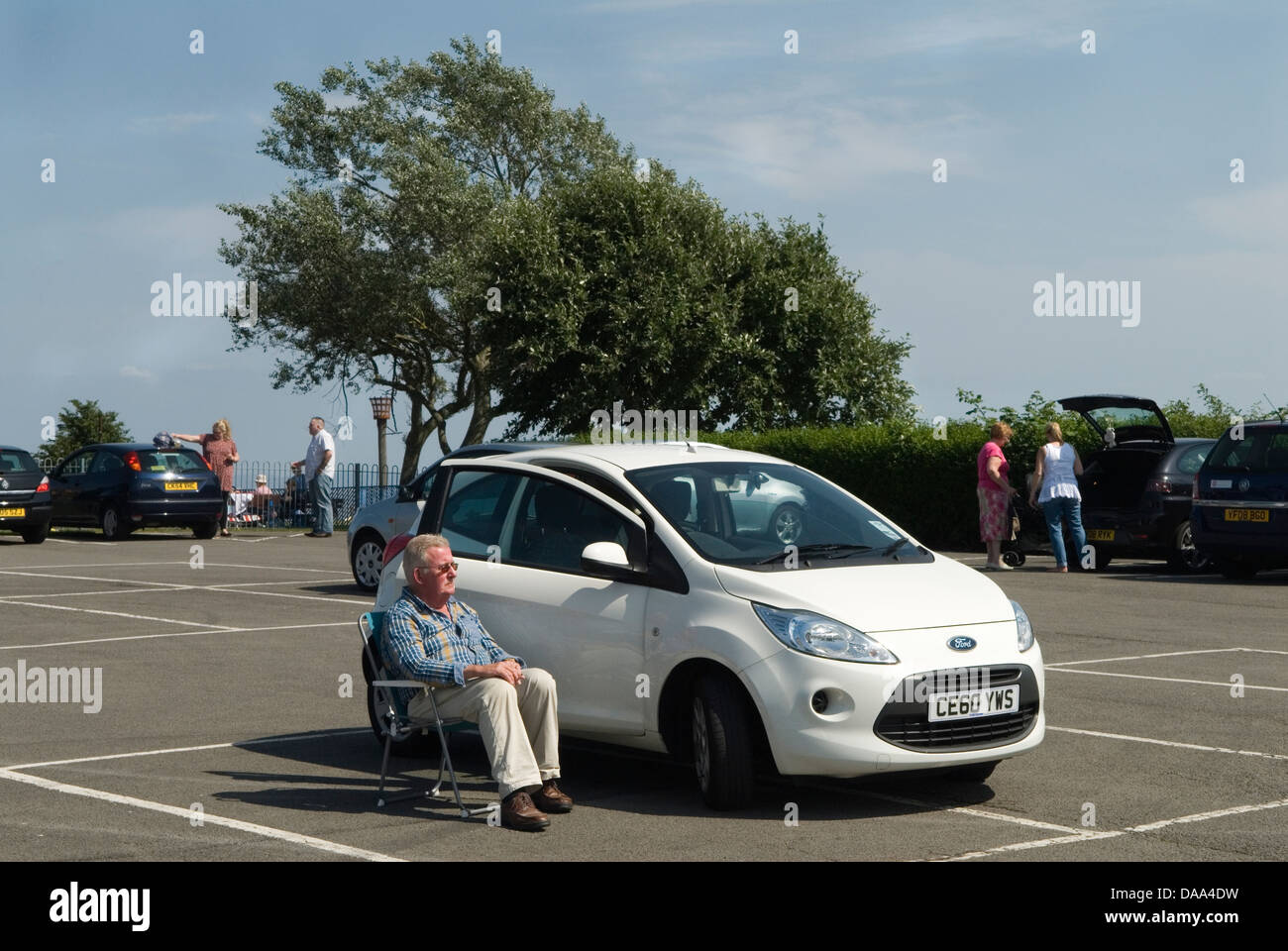 Senior man, oap sunbathing in fold up chair car park . HOMER SYKES Stock Photo Alamy