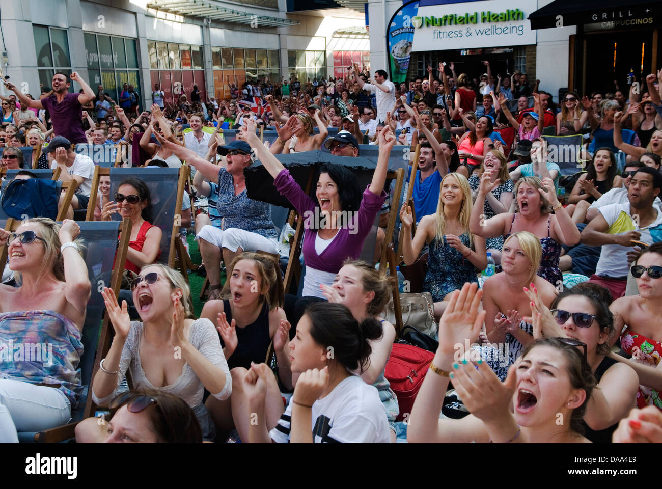 Wimbledon town tennis fans, cheering on Andy Murray They are watching live sport on a large huge outside broadcast TV Television screen. 2013, 2010s UK England HOMER SYKES Stock Photo
