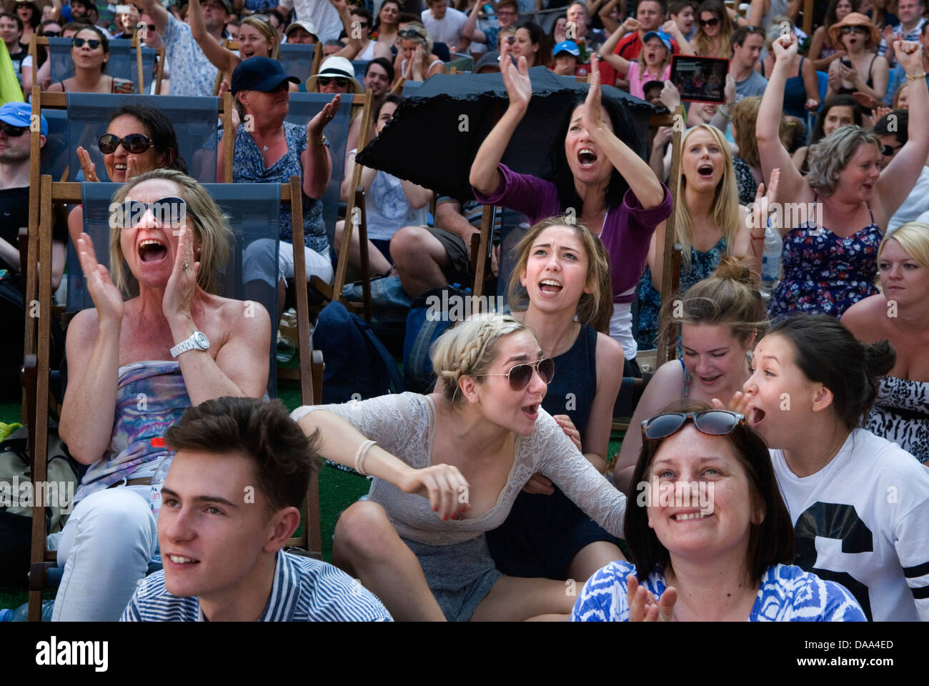 People watching tennis emotions face happy sports fans teenagers teens girls young adults watching live sport on outside huge television TV screen. Happy at the way the game is going, 2013 2010s UK HOMER SYKES Stock Photo