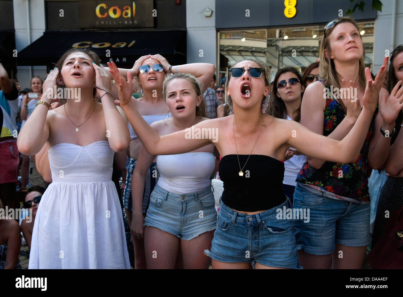 Emotions face unhappy  UK teenage teen girls sports fans watching live sport on outside huge television TV screen. Unhappy disbelief at the way the game is going, 2013 2010s England HOMER SYKES Stock Photo