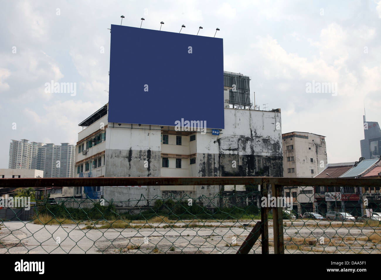 It's a photo of a wasteland or no man's land in the middle of a city in Malaysia. We can a see a big empty outdoor poster Stock Photo