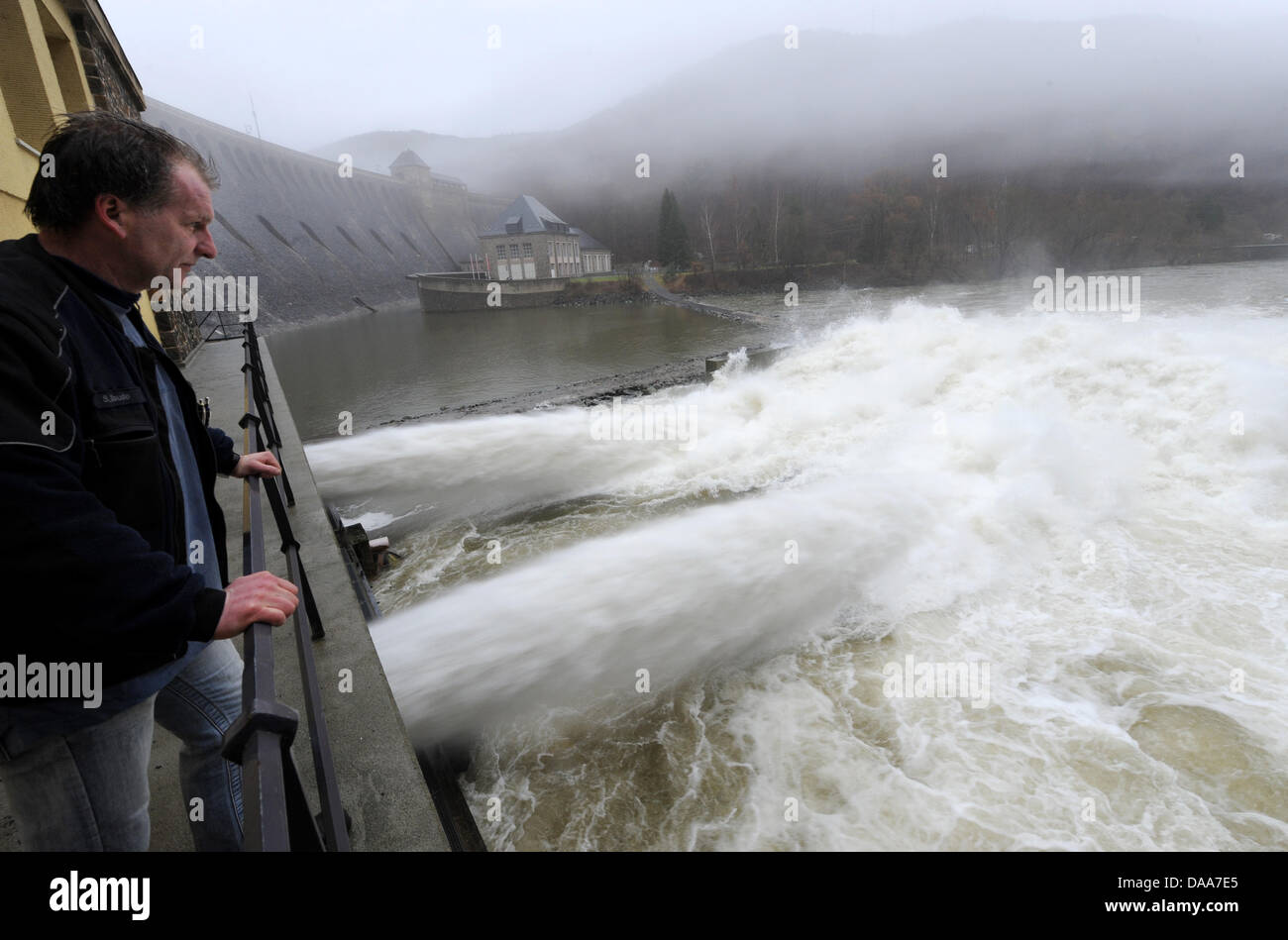 Dam operator Stephan Daude observes water streaming out of two scour outlets at the Edertal dam in Edertal-Hemfurth, Germany, 13 January 2011. The largest reservoir of Hesse is in danger of overrunning, due to heavy rainfall and thaw. Momentarily, water is let out of the reservior via scour outlets to create further storage space. Photo: Uwe Zucchi Stock Photo