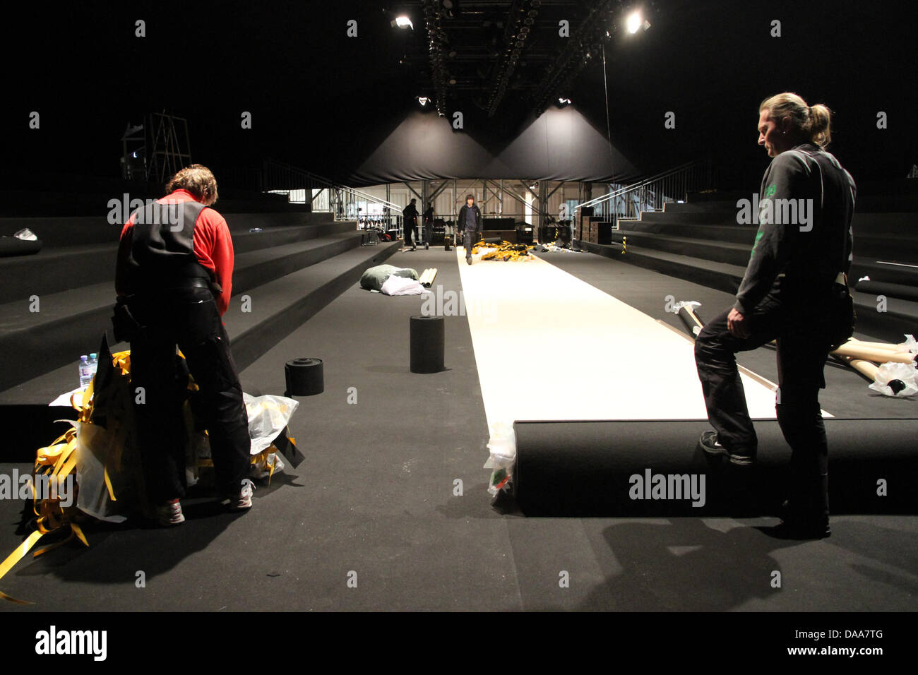 Craftspersons roll out a black carpet inside a tent for the Fashionweek 2011 at the Bebelplatz in Berlin, Germany, 13 January 2011. The Fashionweek, presenting collections of the Autumn and Spring season, takes place from 19-22 January 2011. Photo: Marc Tirl Stock Photo