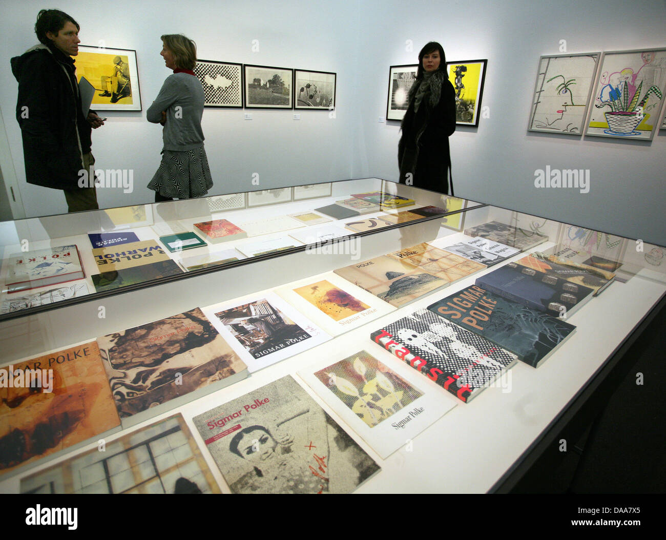 Visitors walk past the work 