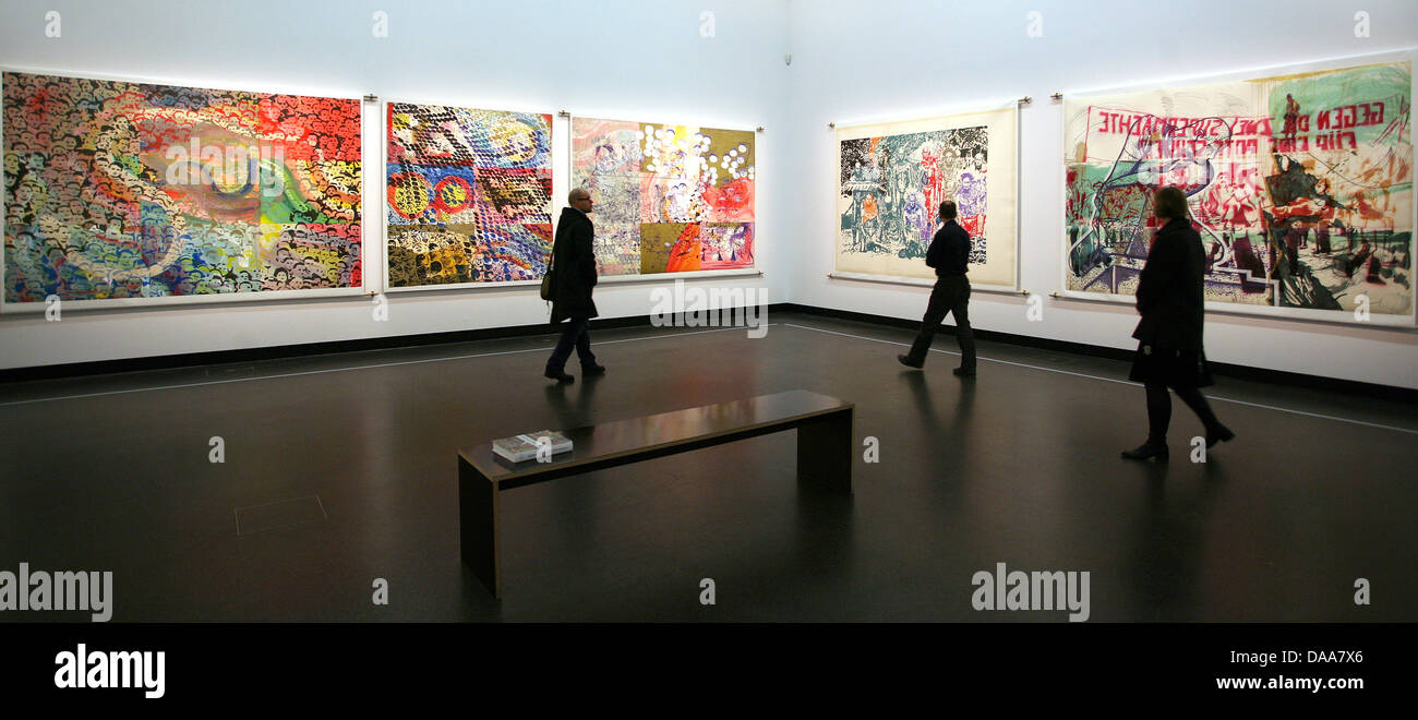 Visitors walk past the work 