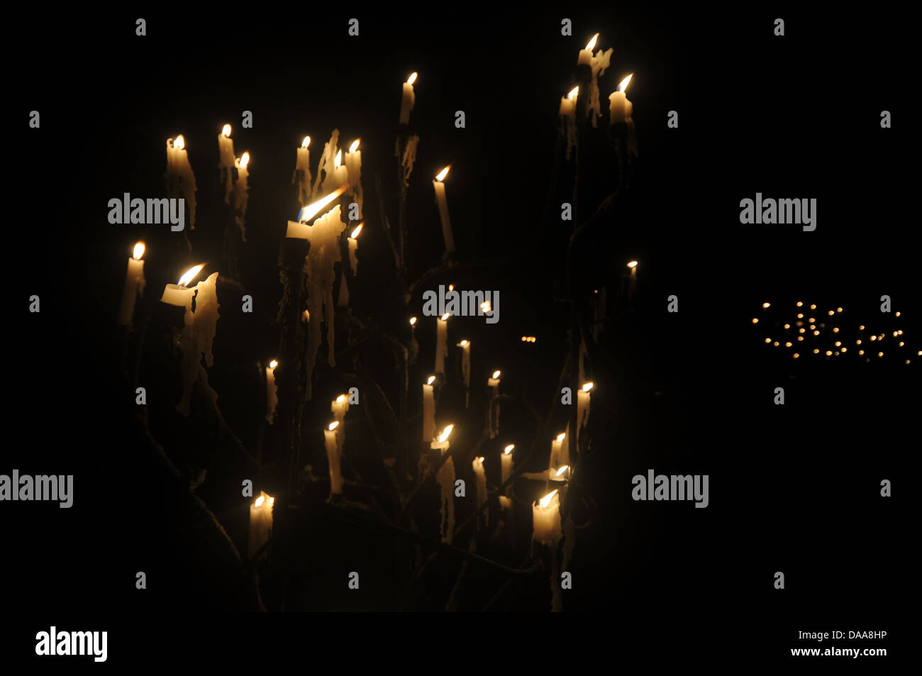Many candles dripping wax in darkened mysterious candelabra Stock Photo