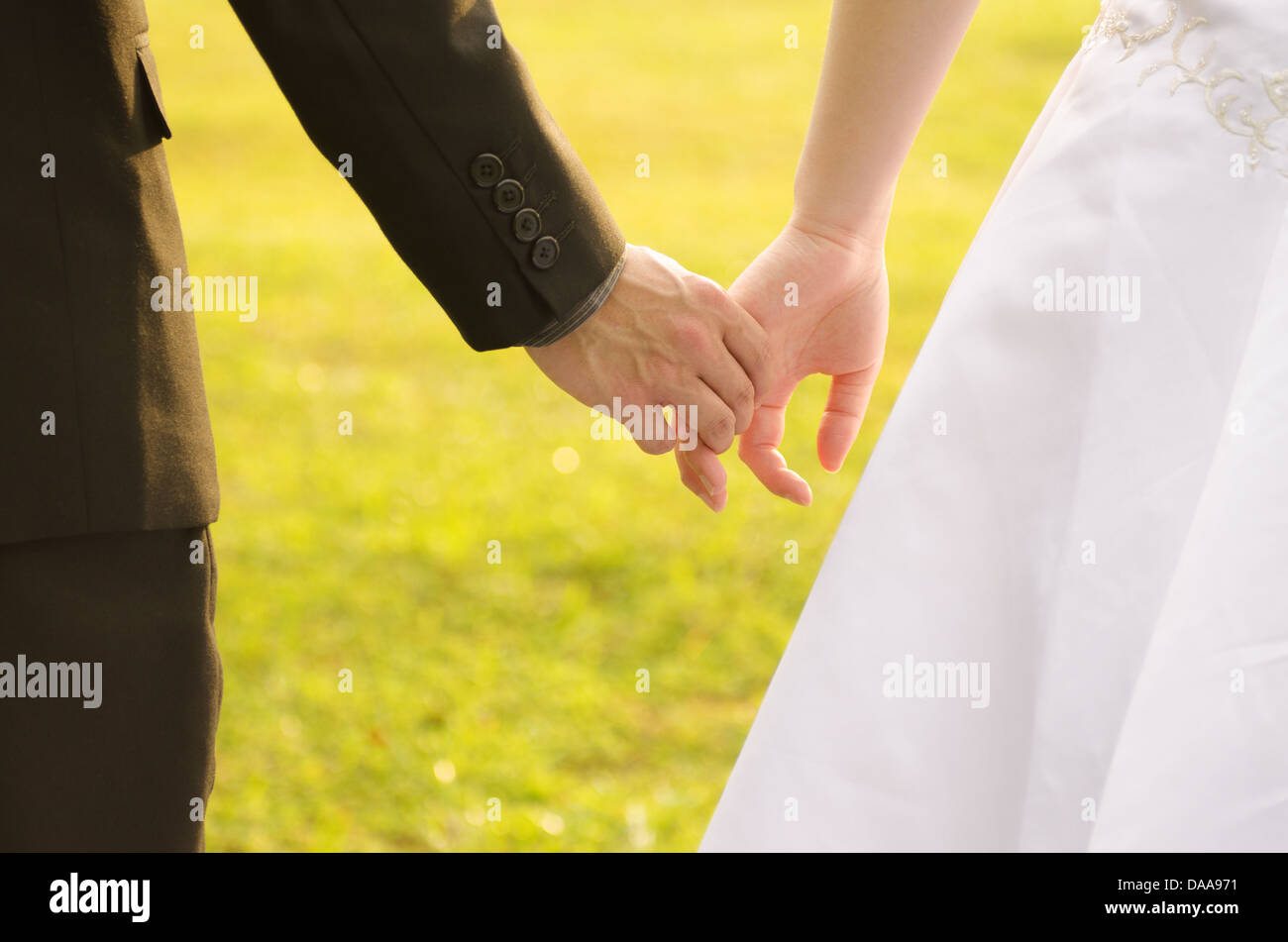 Back view of holding hands couple in love, bride and groom outdoor ...