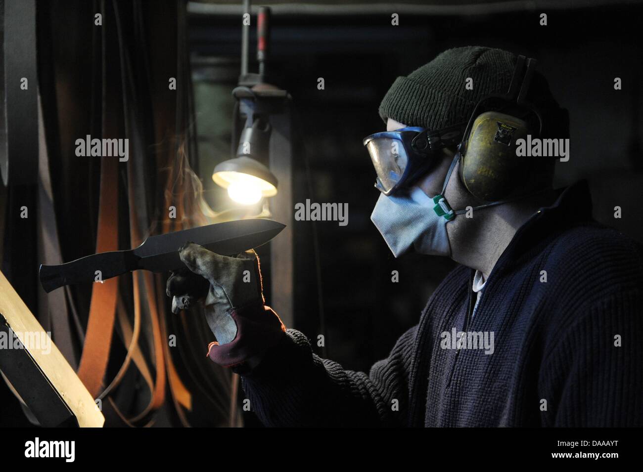 Cuttler Andreas Schweikert checks a knife at his workshop in Moessingen, Germany, 9 December 2010. Schweikert has the option to work in an industrial company, make more money and work less. But the cuttler stays in his almost medieval workshop. He is one of the last professional cuttlers in Germany. Photo: Marijan Murat Stock Photo