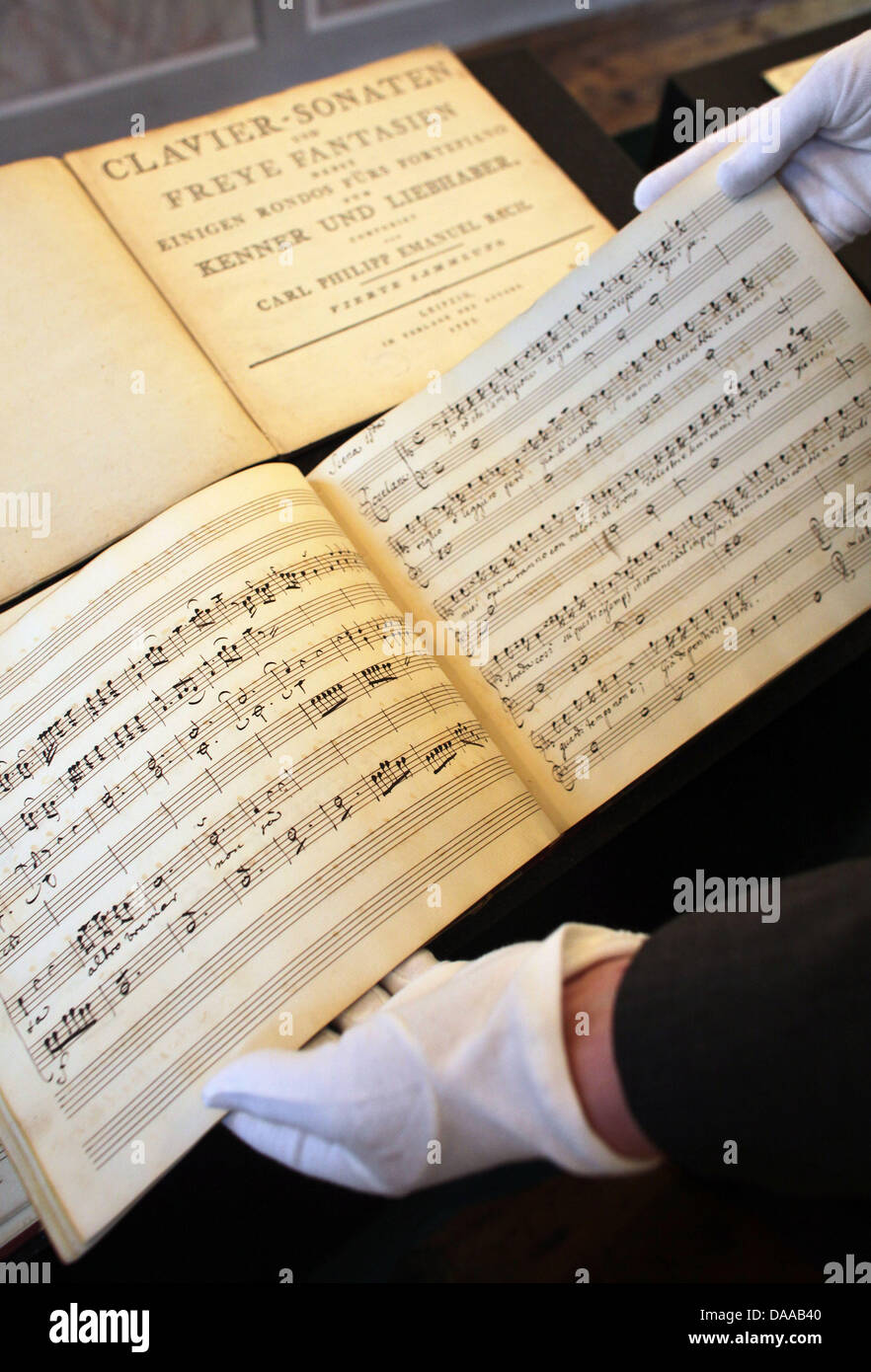 An employee with gloves opens an original score of the Bach opera ...